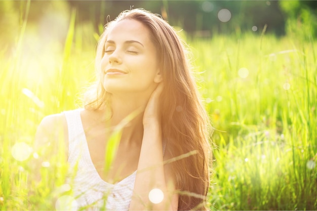 Jonge vrouw op veld onder zonsonderganglicht