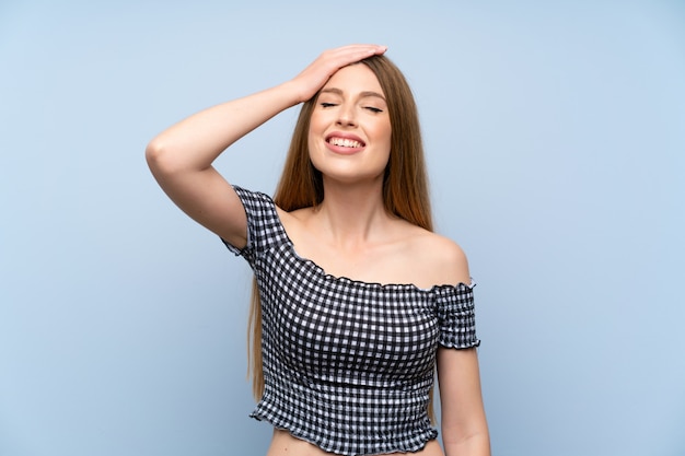 Jonge vrouw over geïsoleerde blauwe achtergrond lachen