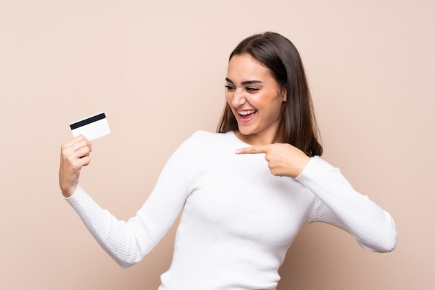 Jonge vrouw over geïsoleerde het houden van een creditcard
