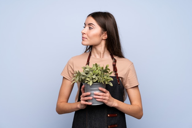 Jonge vrouw over geïsoleerde het nemen van een bloempot