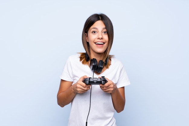 Jonge vrouw over het geïsoleerde blauwe spelen bij videospelletjes