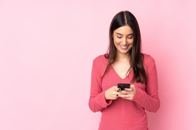 Jonge vrouw over het verzenden van een bericht met de mobiel