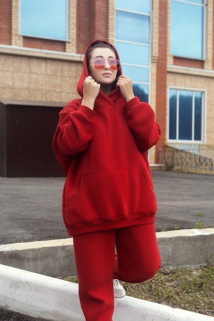 Jonge vrouw poseert in een rood warm casual sportkostuum