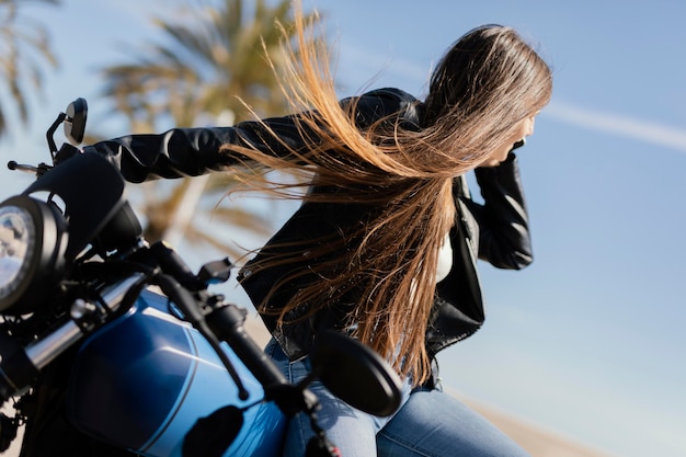 Foto jonge vrouw poseren in een motorfiets