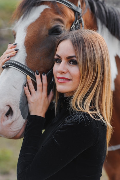 Jonge vrouw poseren met een paard