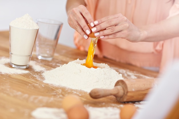 jonge vrouw probeert pierogi te maken in de keuken