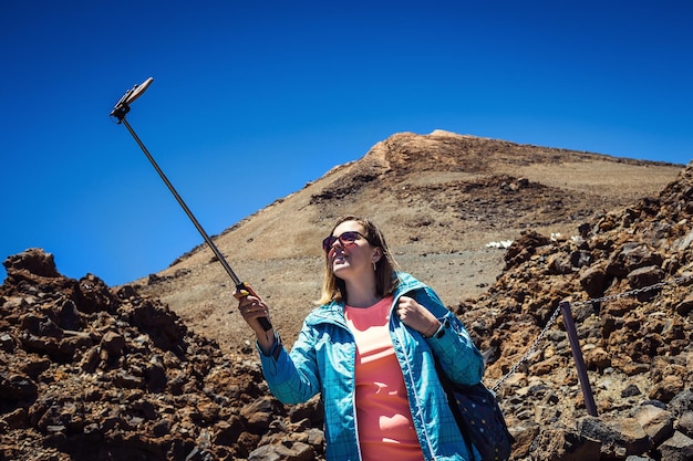 Foto jonge vrouw reiziger in zonnebril maakt selfie met uitzicht op de vulkaan teide op tenerife, canarische eilanden spanje