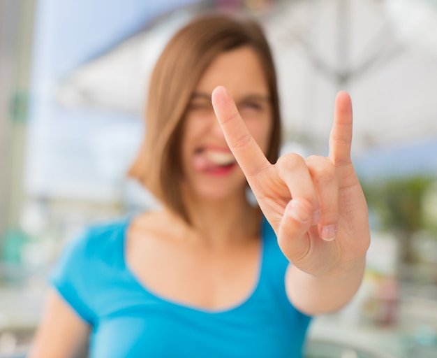 Foto jonge vrouw rock gebaar in een restaurant