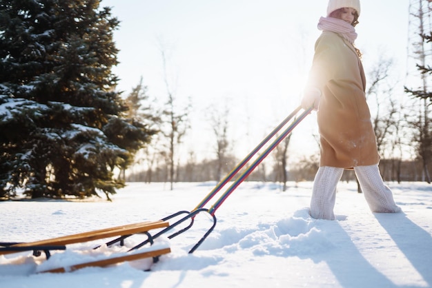 Foto jonge vrouw rolt op een slee in het besneeuwde winterbos natuurvakanties rust reisconcept