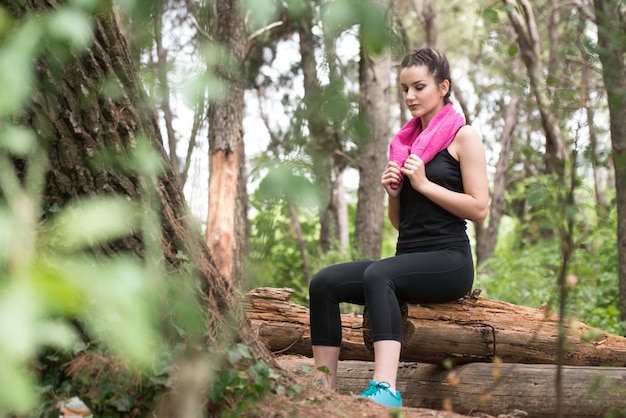 Jonge vrouw rust na het hardlopen In bebost bosgebied training en oefenen voor Trail Run Marathon Endurance Fitness gezonde levensstijl Concept