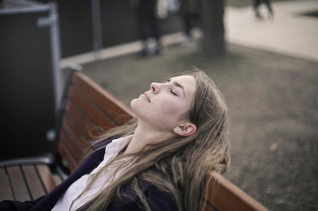 Foto jonge vrouw rust zittend op een bankje
