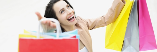 Foto jonge vrouw shopaholic die lacht en blij is met gekochte dingen