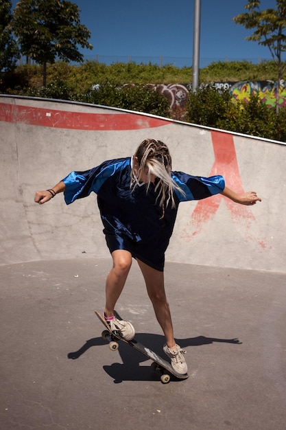 Jonge vrouw skateboarden in skatepark