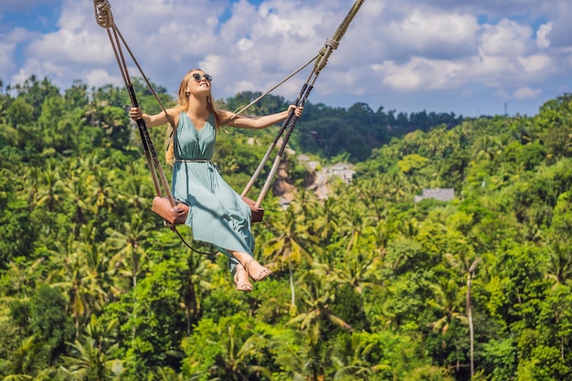 Jonge vrouw slingert in het jungle-regenwoud van het eiland Bali, Indonesië Schommel in de tropen Schommeltrend van Bali