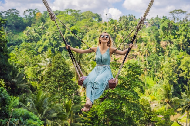 Jonge vrouw slingert in het jungle-regenwoud van het eiland Bali, Indonesië Schommel in de tropen Schommeltrend van Bali