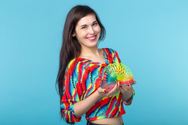 jonge vrouw speelt met een slinky op blauwe muur