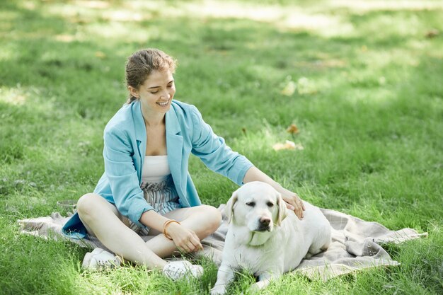 Jonge vrouw speelt met hond in park