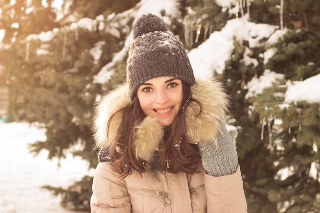 Jonge vrouw speelt met sneeuw en heeft plezier