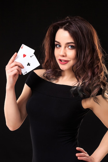 Jonge vrouw spelen in het gokken op zwarte achtergrond