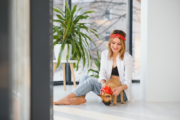 Jonge vrouw spelen met haar hond thuis