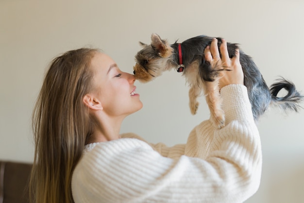 Jonge vrouw spelen met hond op weekenddag thuis. gelukkig yorkshire terrier puppy