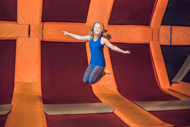 Jonge vrouw sportman springen op een trampoline in fitness park en oefeningen binnenshuis doen