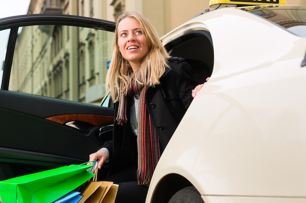 Foto jonge vrouw stapt uit de taxi