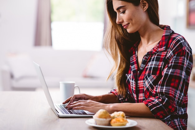 Jonge vrouw te typen op de laptop