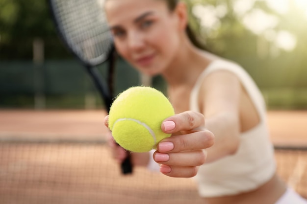 Jonge vrouw tennissen aan het hof focus op de bal