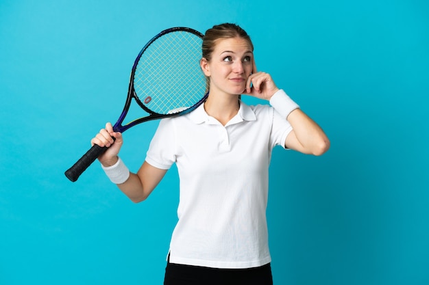 Jonge vrouw tennisser geïsoleerd op blauw twijfels hebben en denken