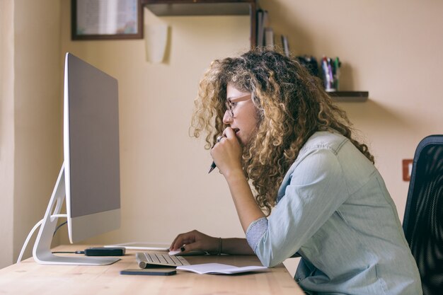 Jonge vrouw thuis of in een klein kantoor werken