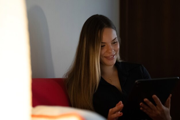 jonge vrouw thuis rustig op de bank kijkend naar de tablet