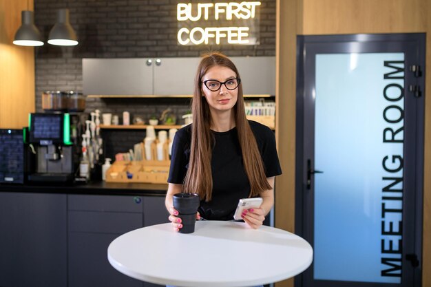 Jonge vrouw tijdens een koffiepauze op kantoor