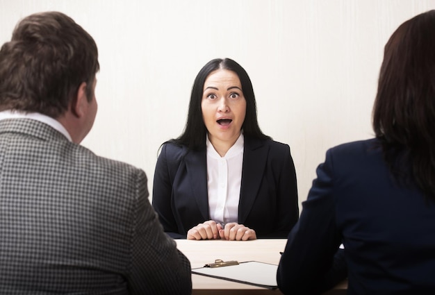 Jonge vrouw tijdens sollicitatiegesprek en leden van management Bang concept