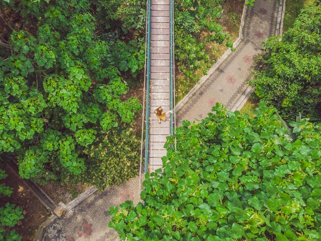 Jonge vrouw toerist bij capilano hangbrug kuala lumpur bos ecopark areial view