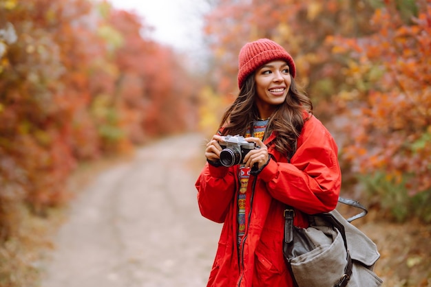 Jonge vrouw toerist fotograferen in herfst bos Rust ontspanning toerisme levensstijl concept