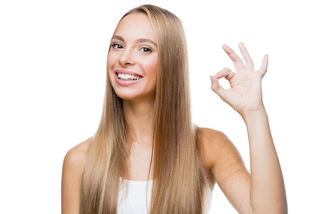 Jonge vrouw toont gebaar ok op witte achtergrond
