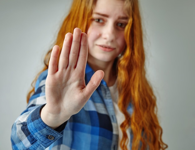 Jonge vrouw toont haar ontkenning met nee op haar hand