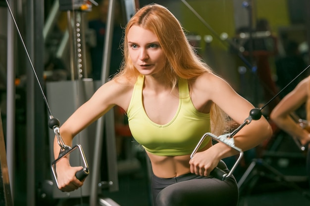 Jonge vrouw training in moderne sportschool