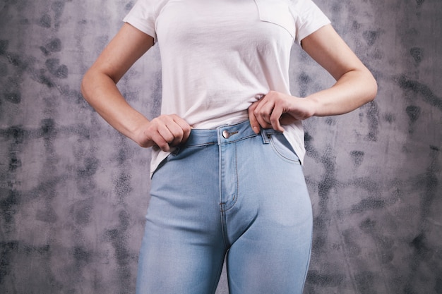 Jonge vrouw trekt jeans aan