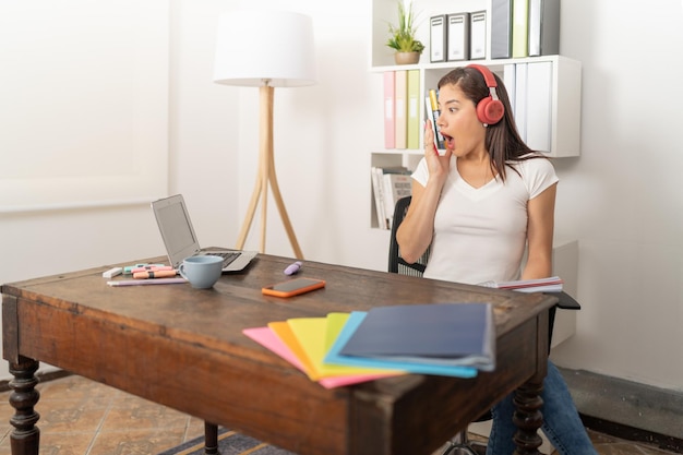 Jonge vrouw verrast luisterend met haar koptelefoon naar de opmerkingen van haar collega's tijdens de vergadering