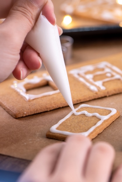 Jonge vrouw versiert peperkoek kerstkoekjes