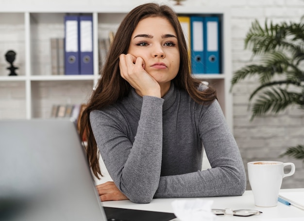 Foto jonge vrouw verveeld tijdens het werken vanuit huis