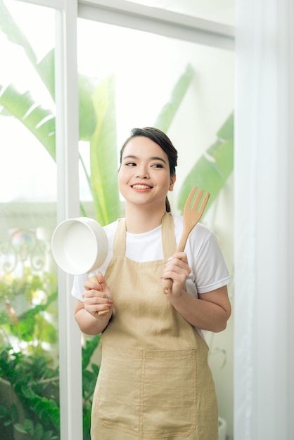 jonge vrouw, vervelend, keukenschort, met, pan