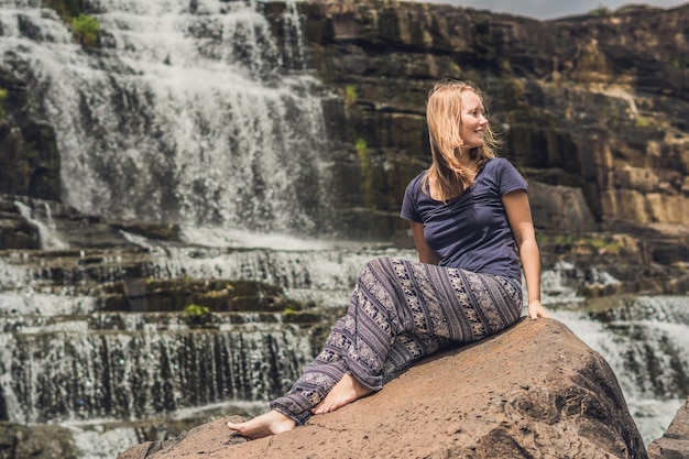 Jonge vrouw wandelaar, toerist op het oppervlak van amazing pongour waterfall is beroemd en mooiste van de herfst in vietnam