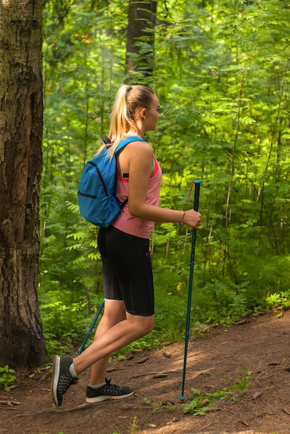 Jonge vrouw wandelen op een pad in een bergbos