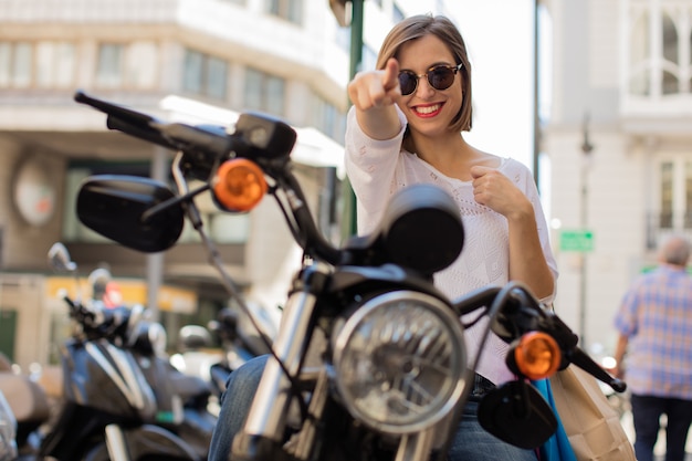 jonge vrouw wijzend op een motorfiets