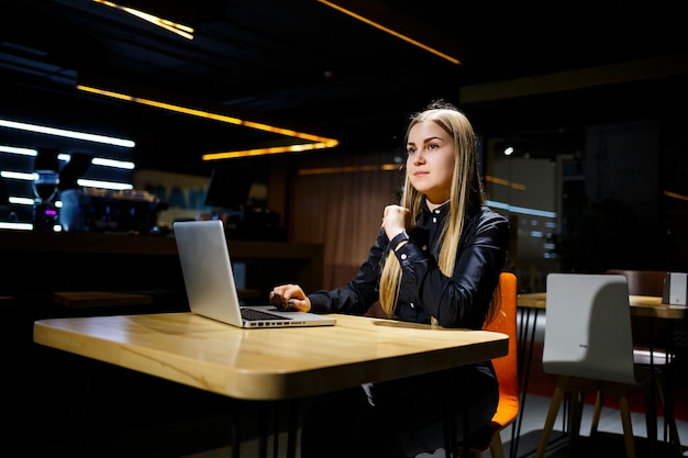 Jonge vrouw zakenman zittend aan een tafel werken met een laptop. Meisjesmanager op kantoor werkt aan een nieuw project