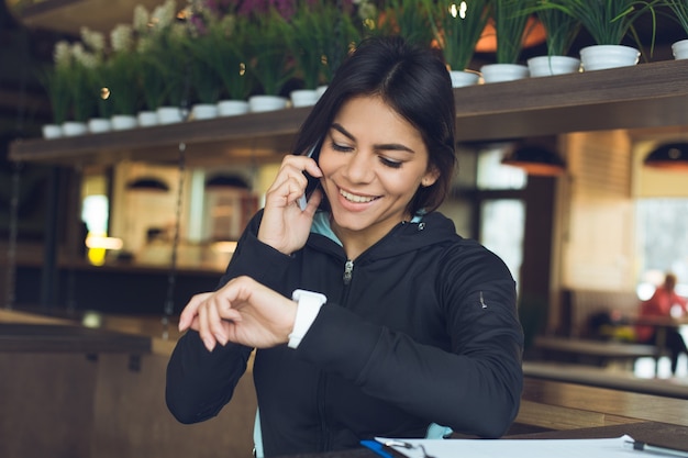 Jonge vrouw zit indoor sportkleding gezonde levensstijl met behulp van digitaal apparaat