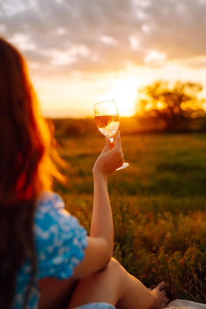 Jonge vrouw zit op een plaid met een boek Zomerpicknick in de natuur Gezonde voeding